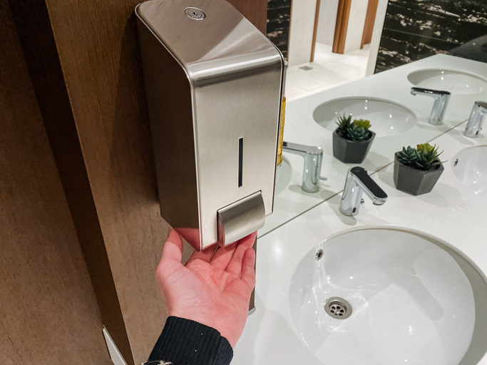 man using touchless fixture in public restroom
